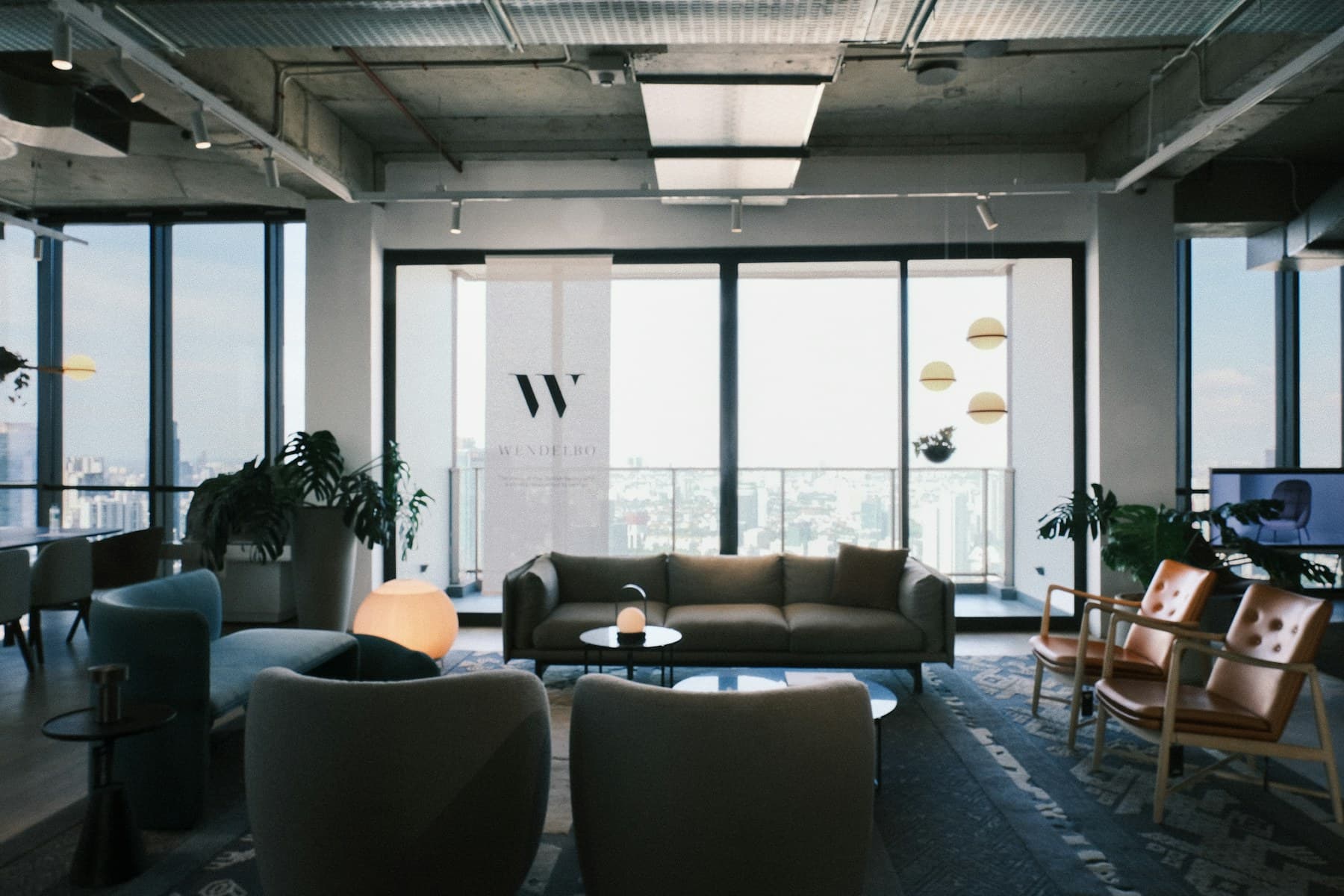 Beautiful modern office lounge with soft seating and city views.